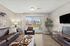 Bright and inviting living room with modern furniture, large sliding glass doors leading to a scenic balcony, and sleek, contemporary decor.