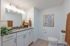 Elegant bathroom with modern fixtures, large mirror, cozy lighting, and stylish decor accents.