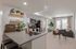 Modern open-concept kitchen and living space with sleek stainless steel appliances, cozy seating area, and abundant natural light.