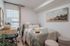 Charming bedroom featuring cozy bedding, elegant artwork, and a stylish desk by a sunlit window.