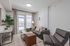 Modern living room featuring sleek gray furniture, natural light from a glass door, and stylish accents for a welcoming atmosphere.