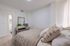 Elegant bedroom with cozy bedding, stylish nightstand, and natural light creating a serene retreat.