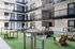 Modern apartment courtyard featuring stylish outdoor seating and vibrant green artificial turf, perfect for social gatherings.