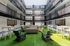 Modern multi-level atrium with stylish seating areas on vibrant artificial grass, perfect for social gatherings and relaxation.