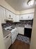 Charming kitchen with elegant white cabinetry, modern appliances, and stylish backsplash in cozy apartment.