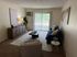 Bright and modern living room with stylish decor, featuring a navy sofa, elegant coffee table, and large window with vertical blinds.