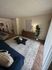 Inviting living room with a modern blue sofa, elegant coffee table on a textured rug, and stylish decor creating a cozy ambiance.