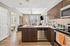 Modern open-concept kitchen and living area with stylish cabinetry and natural light, featuring sleek stainless steel appliances.