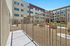 Inviting outdoor apartment courtyard with modern railings, lush green spaces, and cozy seating for relaxation.