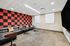 Modern entertainment room with chic leather sofas and retro red and black patterned wall, perfect for relaxation and socializing.