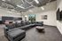 Modern living space featuring a sleek gray sectional sofa, round coffee table, and bright natural lighting, ideal for relaxation and entertainment.