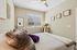 Inviting bedroom with a soft, plush bed, elegant decor, and natural light streaming through a window, creating a serene atmosphere.