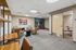 Modern office space with stylish leather chairs, vibrant artwork, and sleek wooden desks perfect for productivity.