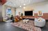 Contemporary lounge area featuring chic seating, large TV, and vibrant decor in a spacious, well-lit room.