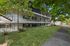 Charming multi-level apartment complex with lush greenery and shaded pathways, offering a serene living environment.