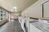 Modern communal laundry room with sleek washing machines, bright natural light, and elegant flooring.