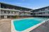 Spacious apartment complex with a pristine swimming pool and modern two-story design.