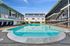 Inviting apartment complex featuring a sparkling swimming pool surrounded by modern architecture and lush greenery.