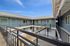 Charming two-story apartment complex with modern design, featuring spacious balcony walkways and a bright, open courtyard.