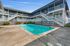 Inviting apartment complex featuring a refreshing outdoor pool, sunlit balconies, and modern design, perfect for relaxed living.