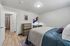 Contemporary bedroom with elegant decor, featuring a cozy bed, stylish wooden dresser, and modern wall accents.