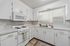 Bright, modern kitchen with sleek white cabinetry, stainless steel sink, and built-in microwave.