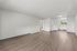Spacious open-concept living and kitchen area featuring sleek hardwood floors and abundant natural light.