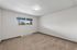 Bright and airy bedroom with fresh carpeting and a large window offering picturesque views.