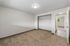 Bright, spacious bedroom with plush carpeting and large closet, featuring a modern light fixture and neutral color palette.