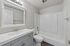 Elegant bathroom with modern fixtures, featuring a sleek vanity, mirrored cabinet, and pristine bathtub for a soothing retreat.