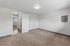 Bright and spacious bedroom with plush carpet and modern lighting, offering a tranquil retreat in a contemporary apartment.