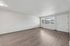 Bright and spacious living room with elegant wooden flooring and large window for natural light.