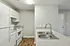 Sleek kitchen design with modern appliances, featuring spacious countertops, elegant dual sinks, and stylish wood flooring.