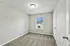 Bright, cozy bedroom with plush carpeting and natural light streaming through a large window.