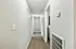 Bright hallway with neutral walls and carpeted flooring leading to multiple rooms, offering a modern and inviting atmosphere.