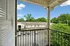 Charming balcony view overlooking a peaceful residential area with lush green trees and parked cars, perfect for relaxation and enjoying tranquil surroundings.