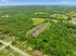 Scenic aerial view of apartment complex nestled in lush greenery, offering serene living with easy access to country roads.