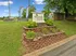 Welcome to Hallmark Columbia Apartment Homes, showcasing vibrant landscaping and a welcoming sign, set against a backdrop of lush greenery.