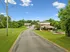 Charming apartment community with brick buildings, lush green lawns, and a playground set against a clear blue sky.
