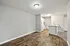 Contemporary apartment with sleek hardwood flooring, cozy kitchen area, and modern lighting design.