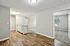 Chic apartment interior showcasing elegant wood flooring in the kitchen and living area, with carpeted bedrooms and ample natural light.