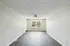 Bright and spacious living area with modern flooring, large window, and stylish ceiling fan, offering a welcoming atmosphere.