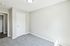 Bright, airy room with fresh neutral paint and soft carpeting, ready for personalization.