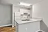 Modern kitchen with sleek white cabinetry, spacious countertop, and stainless steel sink, perfect for culinary enthusiasts.