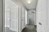 Charming apartment hallway featuring sleek wood floors, bright white doors, and natural light leading to spacious rooms.