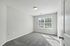 Bright and spacious bedroom with plush gray carpeting and large windows allowing ample natural light.