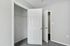 Bright and spacious walk-in closet with sleek white doors and modern carpet flooring.