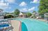 Inviting outdoor swimming pool surrounded by sun loungers and lush greenery, perfect for relaxation and leisure.