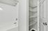 Modern bathroom with a sleek white bathtub and spacious shelving for organized storage.