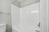 Bright and pristine bathroom space featuring a sleek white bathtub and modern chrome fixtures.